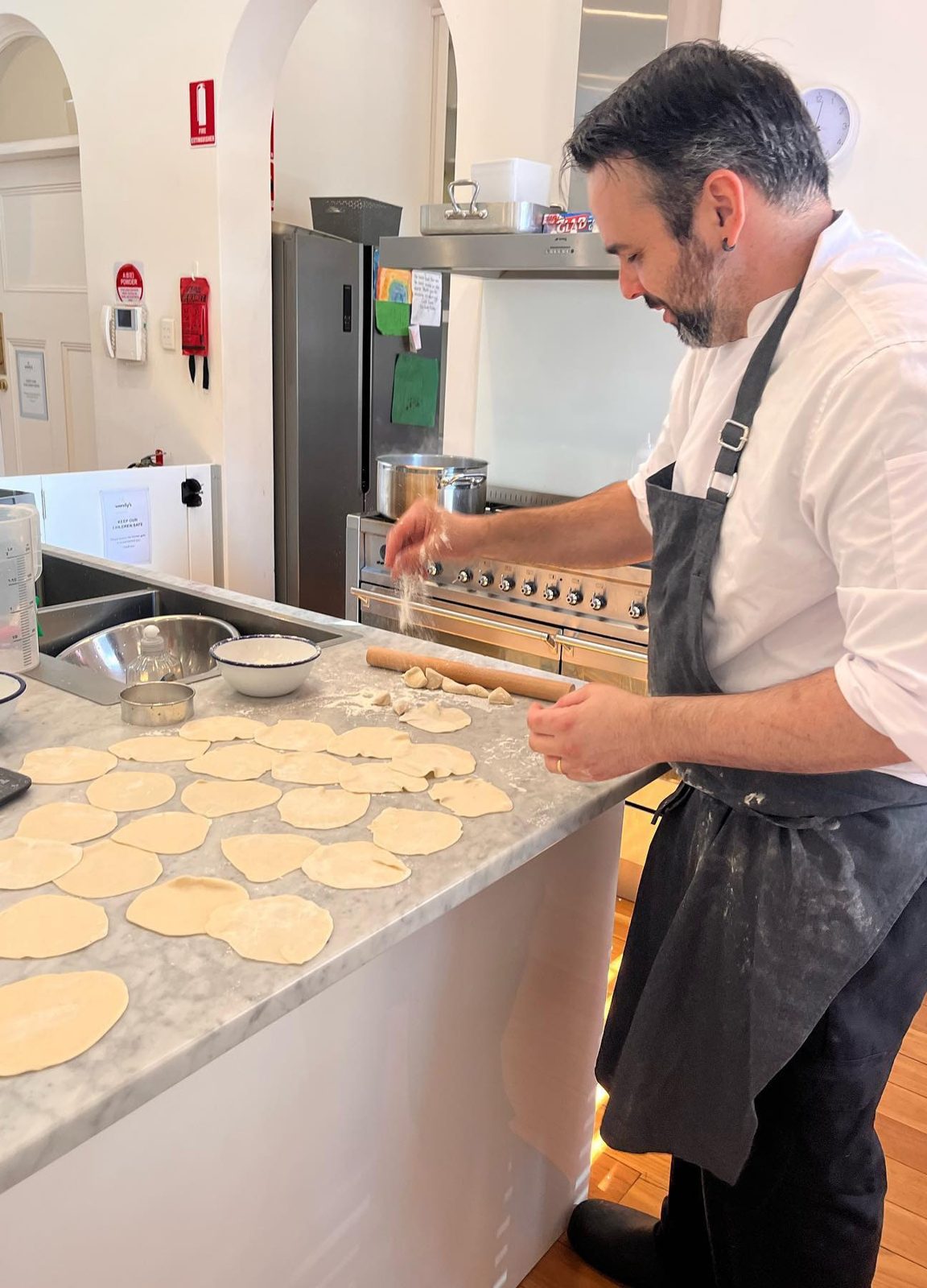 The centre chef rolling out dough in the kitchen